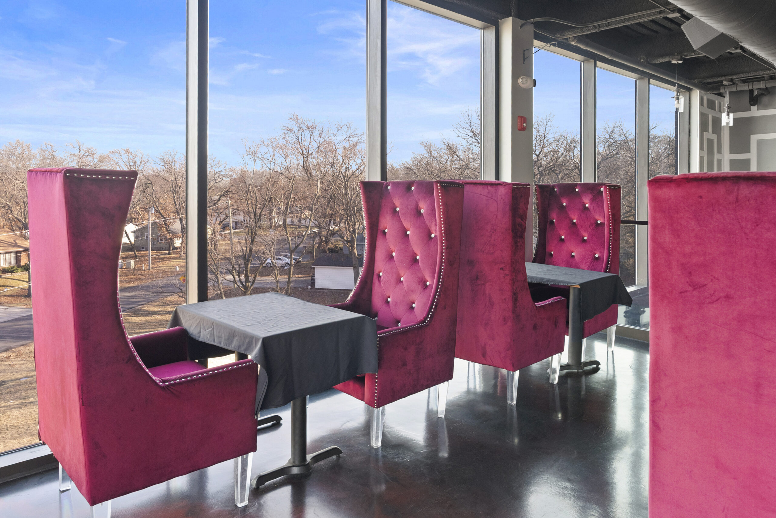 Pink velvet wingback booths by the windows
